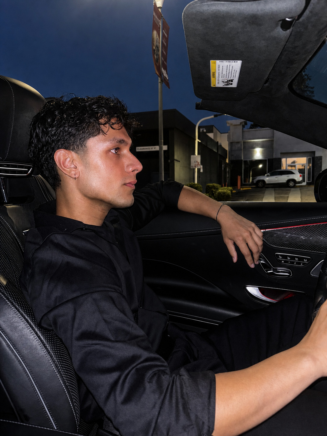 Side-profile portrait of Aryan Mahajan in a black convertible