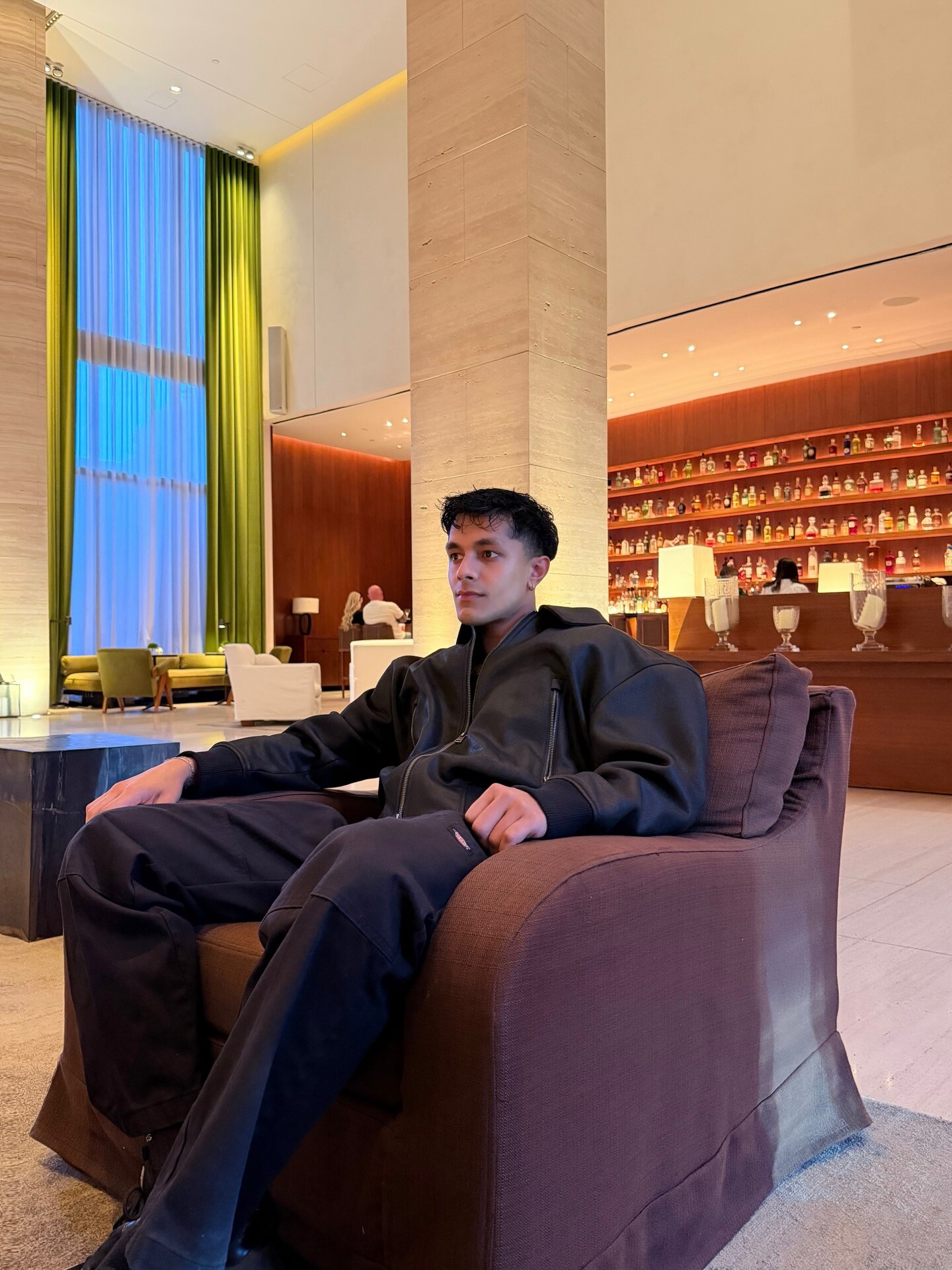Aryan Mahajan seated in a dark lounge wearing a black jacket