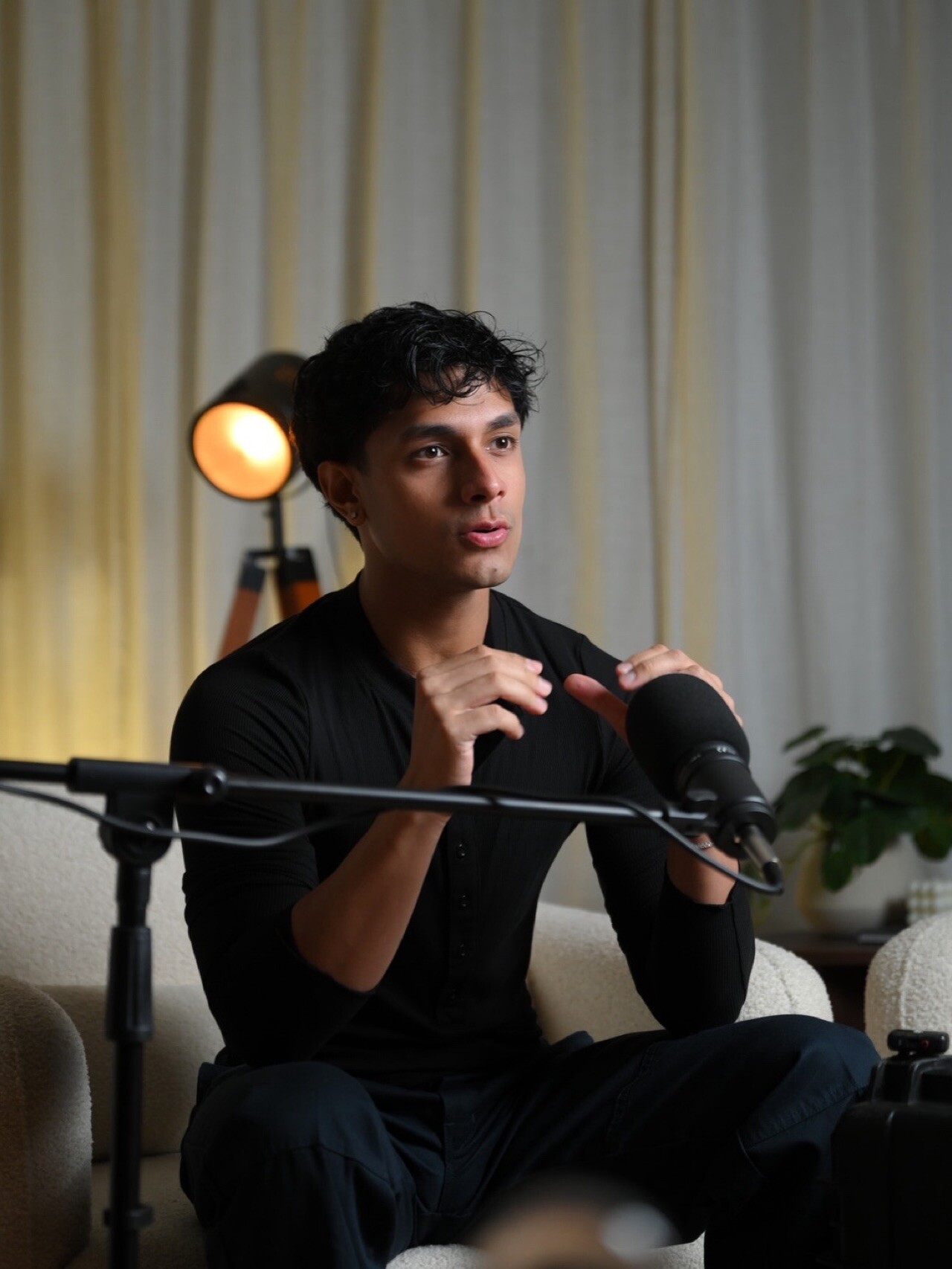 Aryan Mahajan speaking and gesturing into a microphone during a podcast interview