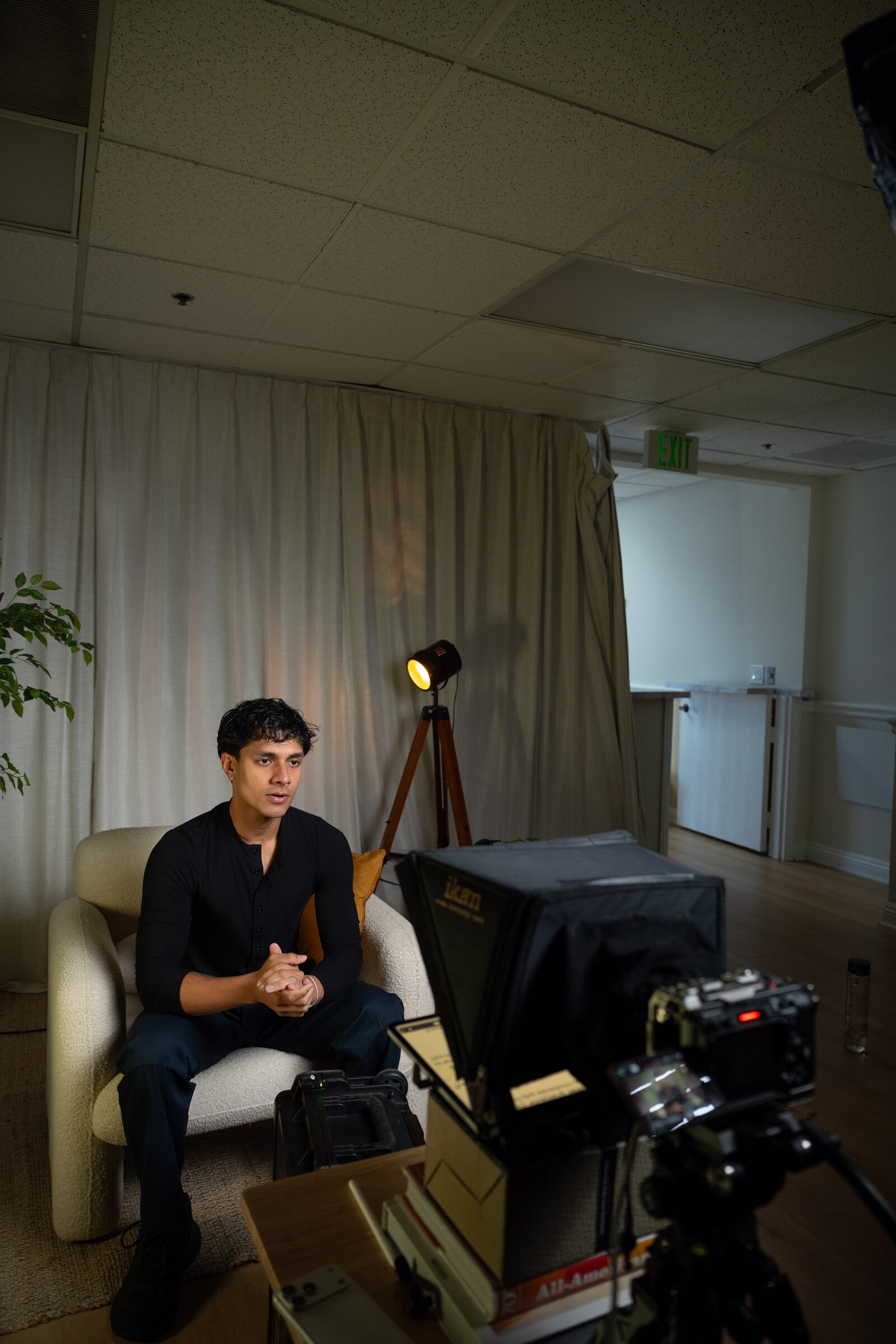 Aryan Mahajan seated on a podcast set behind a production camera