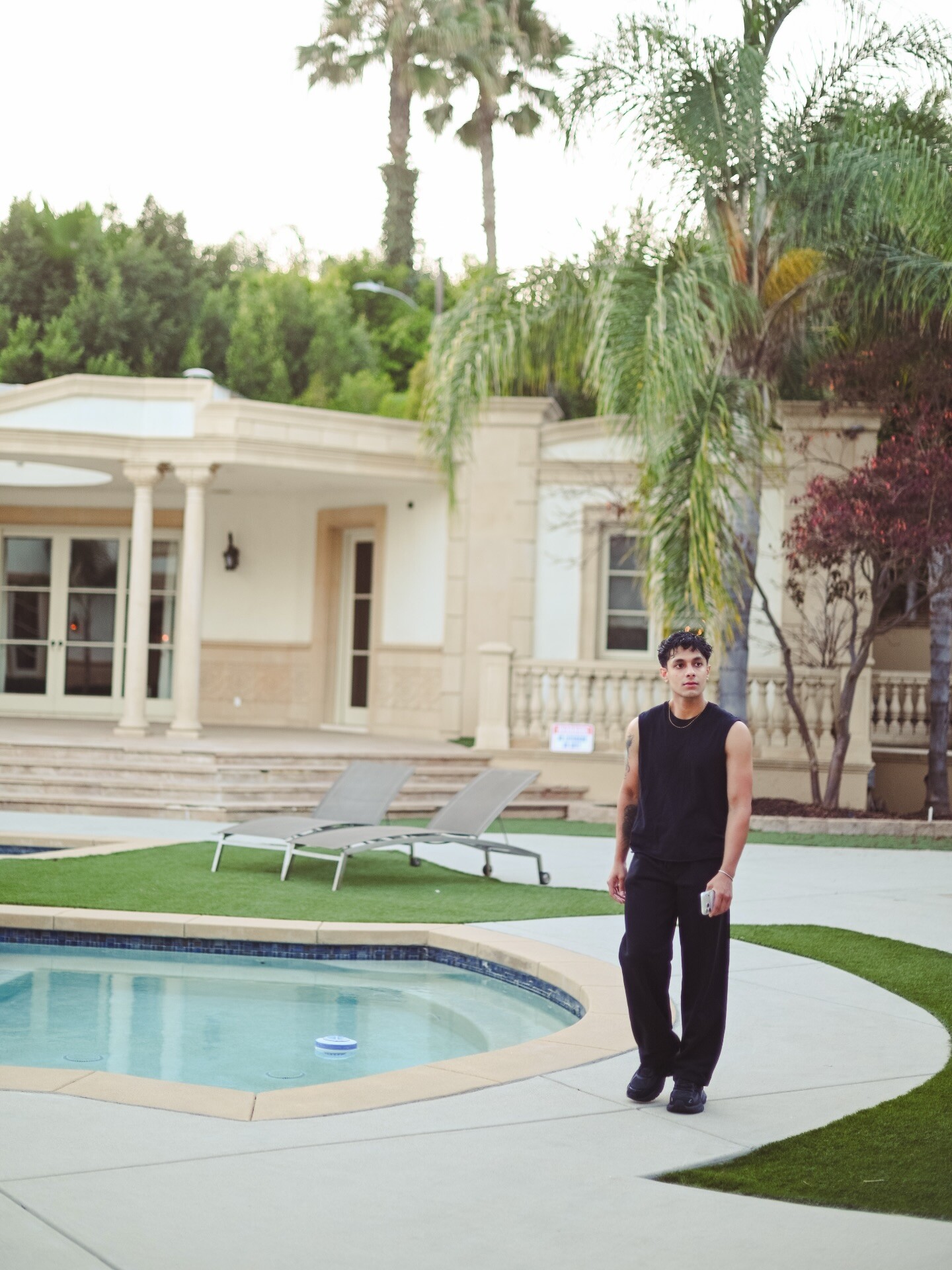 Aryan Mahajan wearing a black tank top beside a Los Angeles pool